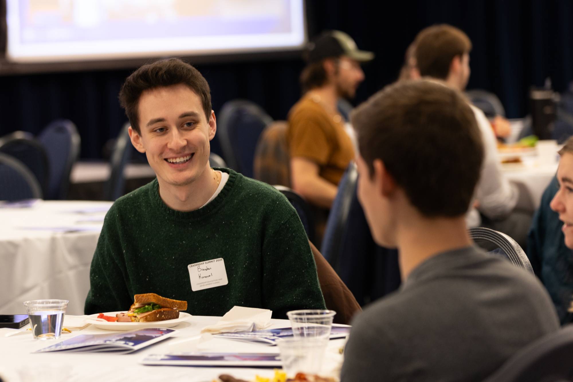 Two students smiling and chatting at a table